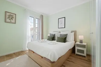 a white bedroom with a large bed and a window at Achada by Homie in Funchal