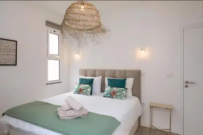 a bedroom with a large white bed with towels on it at RETIRO Da CALHETA in Estreito da Calheta