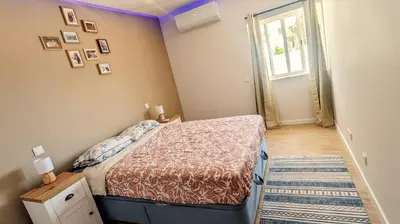 a small bedroom with a bed and a window at luz beach home in Luz