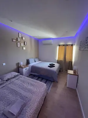 two beds in a room with purple lights at luz beach home in Luz