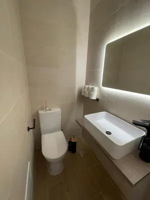 a bathroom with a white toilet and a sink at luz beach home in Luz