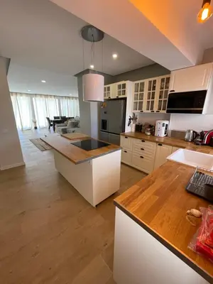 a kitchen with white cabinets and a counter top at luz beach home in Luz