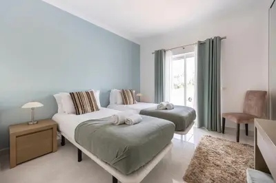 a bedroom with two beds and a window at Villa Ruby in Budens