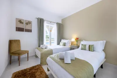 a hotel room with two beds and a chair at Villa Ruby in Budens