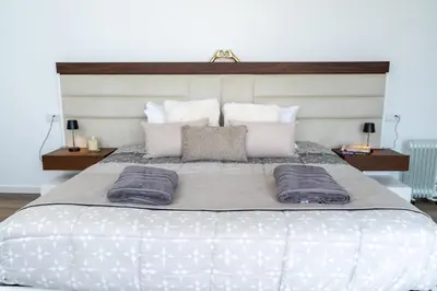 a bedroom with a bed and a large window at Vila Valeria in Funchal
