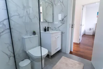 a white bathroom with two sinks and a mirror at Vila Valeria in Funchal