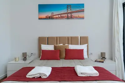 a bedroom with a bed with red pillows and a balcony at Vila Valeria in Funchal
