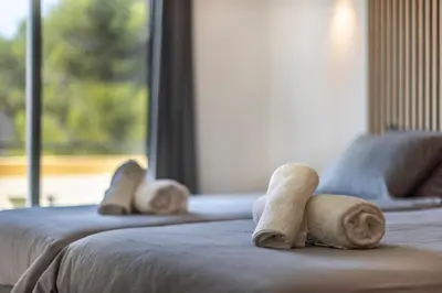 a group of three beds with towels on them at Sagres ZEN - 3 Bedroom House in Sagres