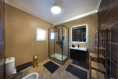 a bathroom with a shower and a toilet and a sink at Sagres ZEN - 3 Bedroom House in Sagres