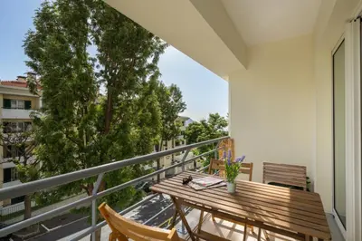 a balcony with a wooden table and chairs at OurMadeira - Madalena Living Apt in Funchal