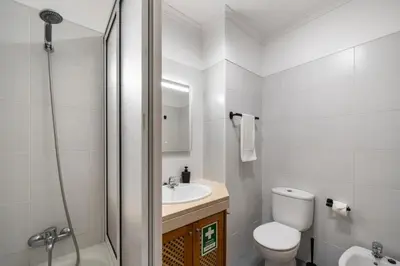 a white bathroom with a toilet and a sink at OurMadeira - Madalena Living Apt in Funchal