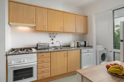 a kitchen with wooden cabinets and a sink and a dishwasher at OurMadeira - Madalena Living Apt in Funchal