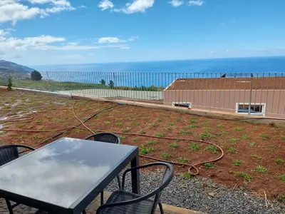 a patio with a table and chairs and the ocean at Casa Caipirinha in Prazeres
