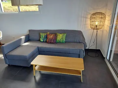 a living room with a blue couch and a table at Casa Caipirinha in Prazeres