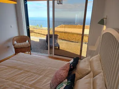 a bedroom with a bed and a view of the ocean at Casa Caipirinha in Prazeres