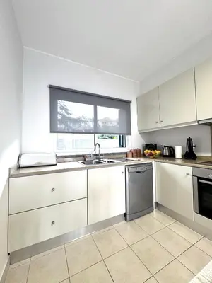 a kitchen with white cabinets and a sink and a window at Sunset Dreams - Arco da Calheta in Arco da Calheta