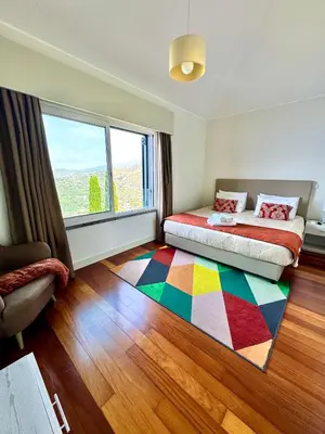 a bedroom with a bed and a colorful rug at Sunset Dreams - Arco da Calheta in Arco da Calheta
