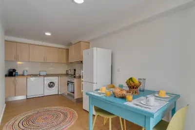a kitchen with a blue table and a refrigerator at Maria Madalena in Madalena do Mar