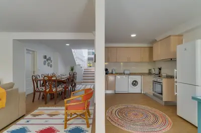 a kitchen and a living room with a table and chairs at Maria Madalena in Madalena do Mar