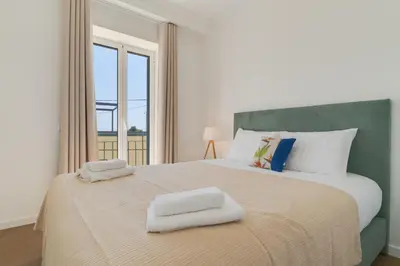 a bedroom with a large bed with two towels on it at Maria Madalena in Madalena do Mar