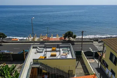 a view of a building with the ocean in the background at Maria Madalena in Madalena do Mar