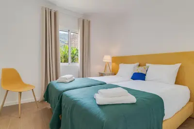 a bedroom with a bed with two towels on it at Maria Madalena in Madalena do Mar