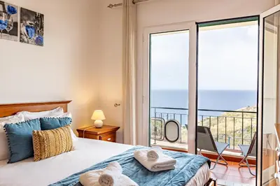 a bedroom with a bed and a view of the ocean at Pérola Apartments by YOUR KEY in Caniço
