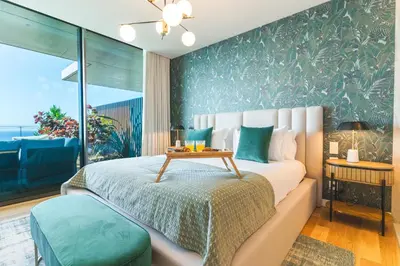 a bedroom with a bed with a table on it at Seaside Escape by Atlantic Holiday in Funchal