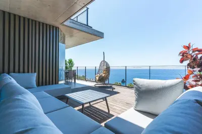 a living room with a couch and a view of the ocean at Seaside Escape by Atlantic Holiday in Funchal