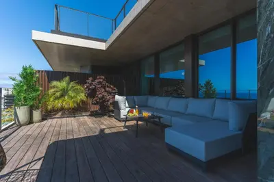 a living room with a blue couch on a deck at Seaside Escape by Atlantic Holiday in Funchal