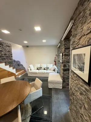 a living room with a couch and a stone wall at Atelier II by Real Vision in Funchal