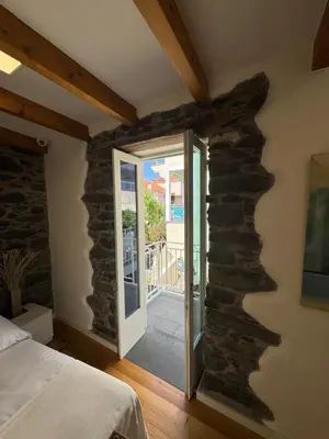 a bedroom with a stone wall with a glass door at Atelier II by Real Vision in Funchal