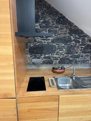 a kitchen with a sink and a stone wall at Atelier II by Real Vision in Funchal