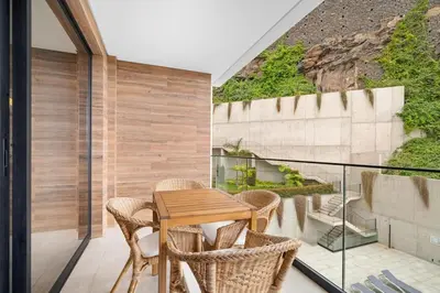 a balcony with a wooden table and chairs at MK Apart I in Funchal