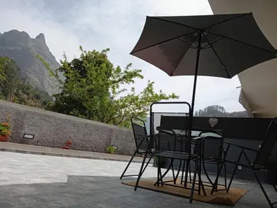 a table and chairs with an umbrella on a patio at Danny's Rural Suite T2 in Curral das Freiras
