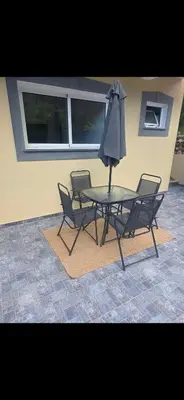 a table with two chairs and an umbrella at Danny's Rural Suite T2 in Curral das Freiras