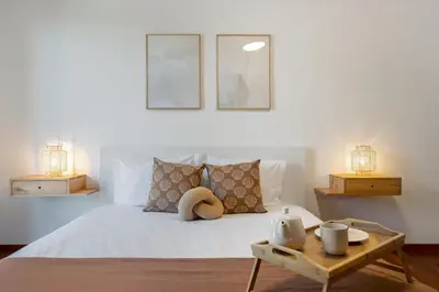 a bedroom with a bed with two lamps and a table at Wings Apartment II by An Island Apart in Santa Cruz