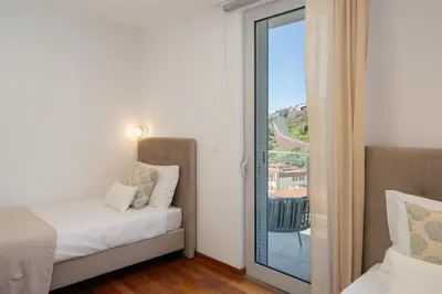 a bedroom with a bed and a sliding glass door at Wings Apartment II by An Island Apart in Santa Cruz