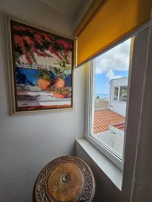 a room with a window and a painting and a table at Talefe Apartment in Luz