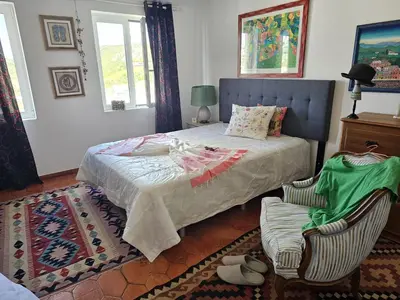 a bedroom with a bed and a chair in it at Talefe Apartment in Luz