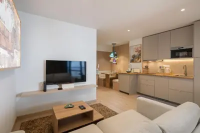 a living room with a couch and a tv on a wall at Monumental Studio 10 by An Island Apart in Funchal