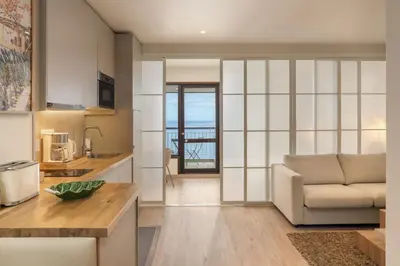 a living room with a couch and a kitchen at Monumental Studio 10 by An Island Apart in Funchal