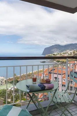 a table on a balcony with a view of the ocean at Monumental Studio 10 by An Island Apart in Funchal
