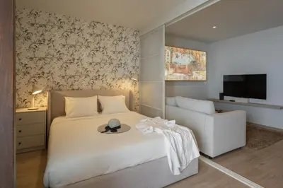 a bedroom with a bed and a chair and a television at Monumental Studio 10 by An Island Apart in Funchal
