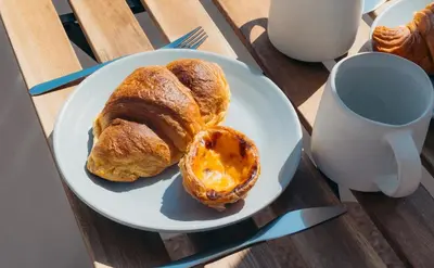 a plate of pastries on a table with a cup of coffee at Casa Calma II - 2 double bedrooms apartment in Luz