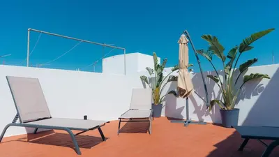 two chairs and an umbrella on a balcony with plants at Casa Calma II - 2 double bedrooms apartment in Luz