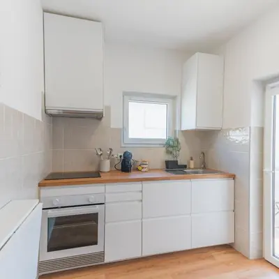 a white kitchen with white cabinets and a window at Casa Calma II - 2 double bedrooms apartment in Luz