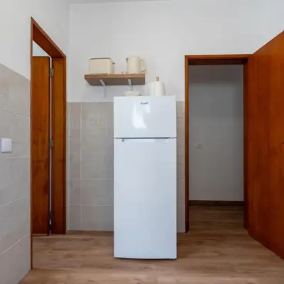 a white refrigerator in a room with a door at Casa Calma II - 2 double bedrooms apartment in Luz