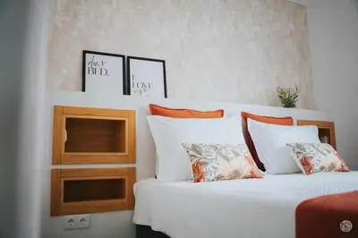 a bedroom with two beds with white sheets and orange pillows at Casa da Carreira in Almagreira