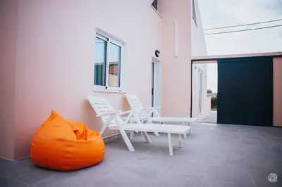 two white chairs and an orange bag on a patio at Casa da Carreira in Almagreira